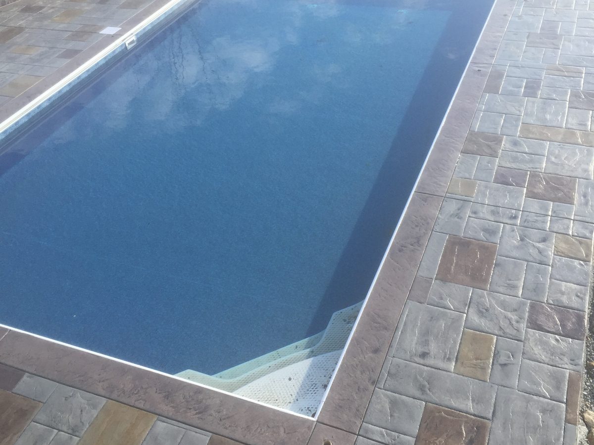 Pool coping edge and deck slope carrying water away from the pool shell