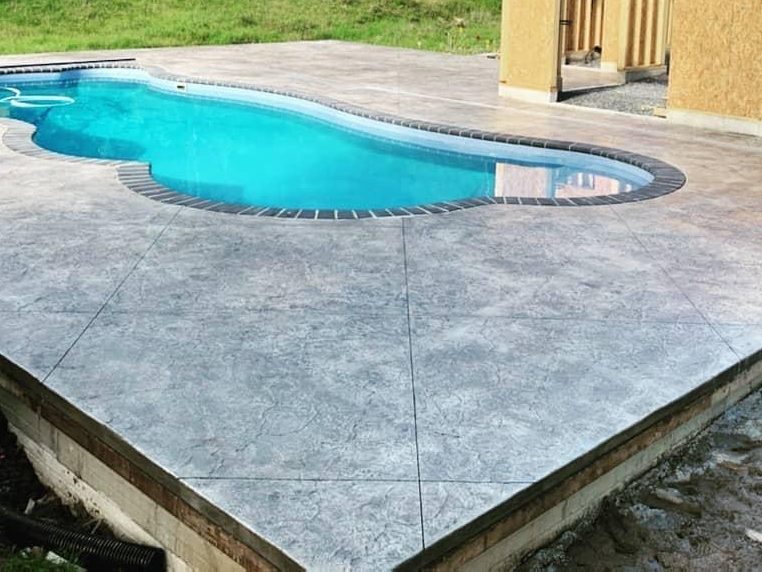 Light gray concrete pool deck that stays cooler underfoot in the summer sun