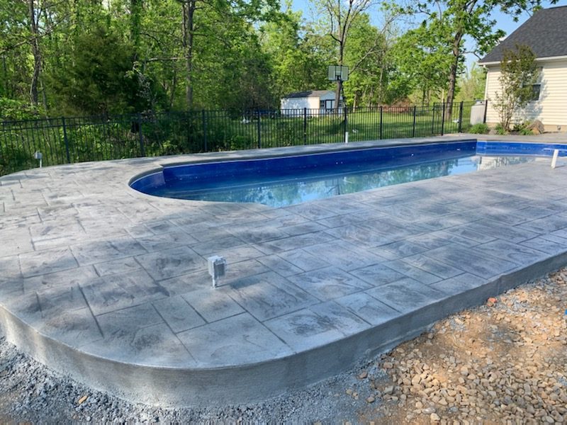 Resurfaced pool deck with smooth coping and a light broom finish
