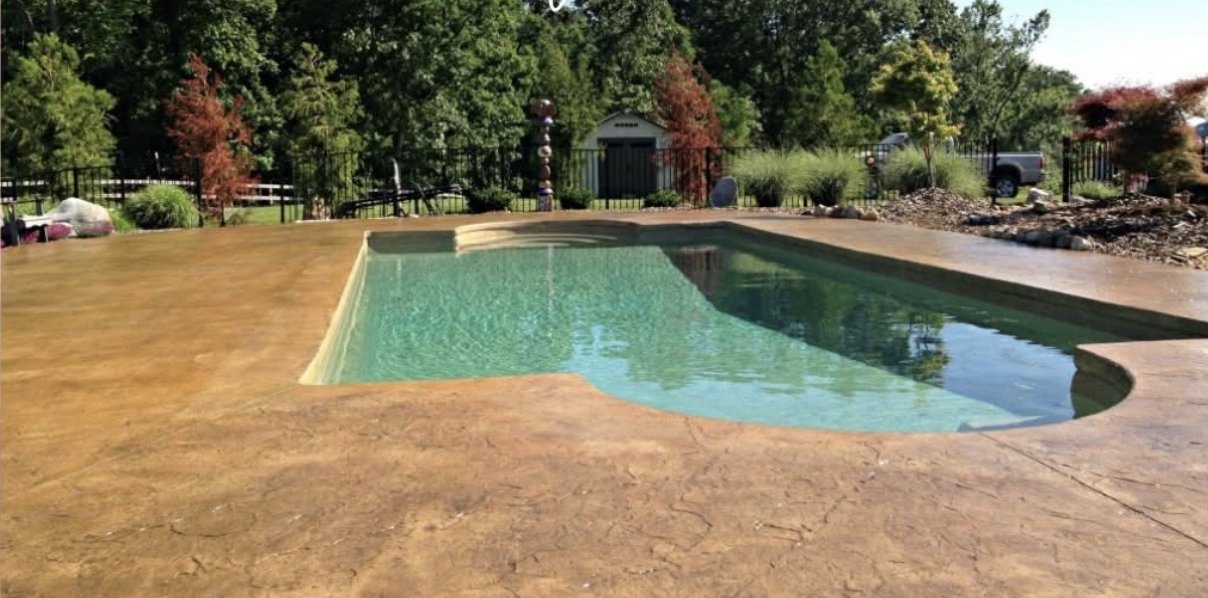 Tan stamped concrete pool deck wrapping a swimming pool in Winchester VA