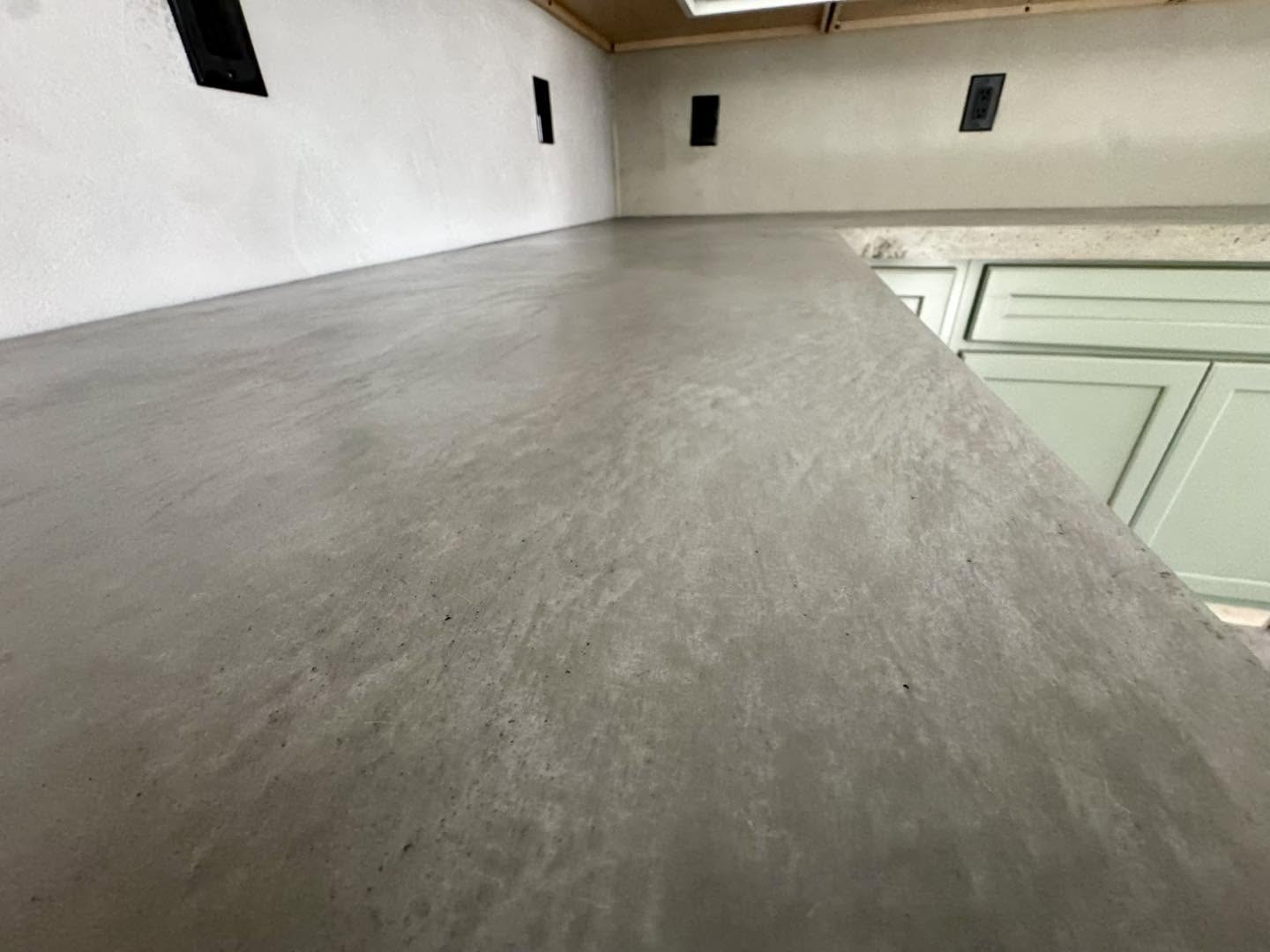 Polished concrete countertop against green cabinetry in Winchester VA