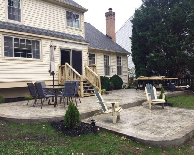 Stamped concrete patio and seating beside a brick chimney in Winchester VA