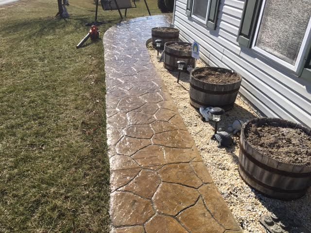 Flagstone pattern concrete walkway beside whiskey barrel planters in Winchester VA