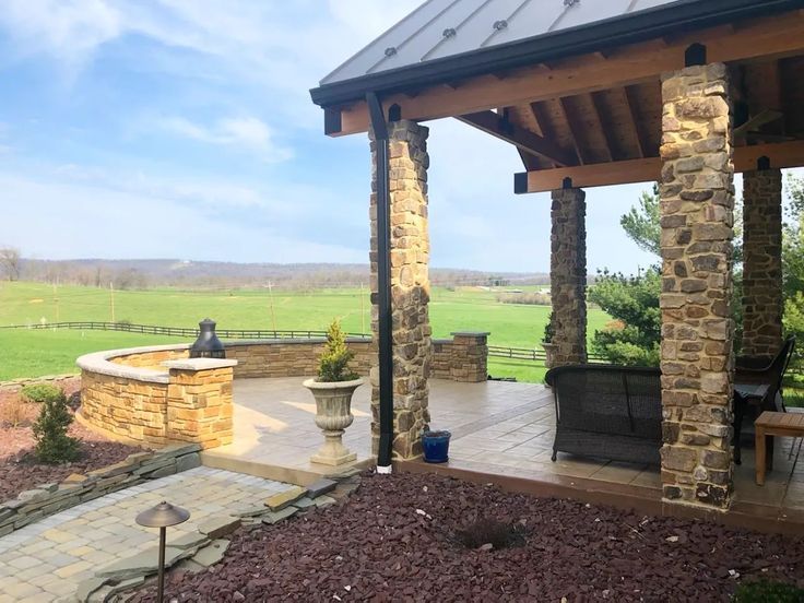 Outdoor living pavilion with a concrete firepit and stone columns in Winchester VA